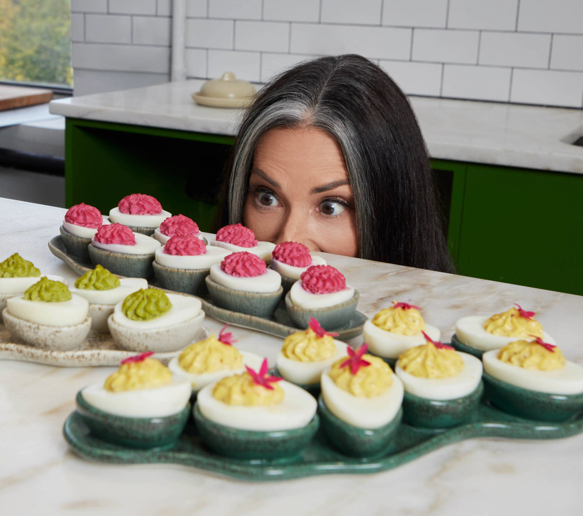stacy peers over the counter to look at the deviled egg trays